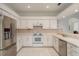 White kitchen with stainless steel refrigerator, white appliances and lots of cabinet space at 1156 Ridgegrove W Dr, Palm Harbor, FL 34683