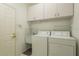 Clean laundry room with washer, dryer, utility sink, and plenty of storage at 1156 Ridgegrove W Dr, Palm Harbor, FL 34683