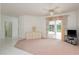 Cozy living room with a sliding door to the patio, a ceiling fan, and neutral carpet at 1156 Ridgegrove W Dr, Palm Harbor, FL 34683