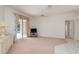 Bright living room with a ceiling fan, carpeted flooring, and sliding glass doors to the pool area at 1156 Ridgegrove W Dr, Palm Harbor, FL 34683