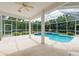 Covered lanai with a sparkling pool providing a relaxing space surrounded by lush landscaping at 1156 Ridgegrove W Dr, Palm Harbor, FL 34683