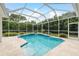 Inviting screened-in pool with a sparkling blue water, surrounded by lush landscaping at 1156 Ridgegrove W Dr, Palm Harbor, FL 34683