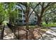 Attractive condominium complex with a boardwalk, screened in patios, and mature trees on a bright sunny day at 1201 High Hammock Dr # 302, Tampa, FL 33619