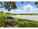 Beautiful pond with a bench and a walking path surrounded by lush greenery under a blue sky at 1201 High Hammock Dr # 302, Tampa, FL 33619