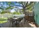 The backyard features a patio, green grass, and a deck, all under the shade of a mature tree at 1208 E Crenshaw St, Tampa, FL 33604