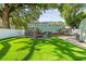 Lush green backyard featuring a fire pit, seating area, and well-maintained lawn at 1208 E Crenshaw St, Tampa, FL 33604