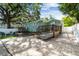 Inviting backyard with a stone patio, an outdoor seating area, and a charming green house at 1208 E Crenshaw St, Tampa, FL 33604