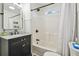 Bathroom showcasing vanity with marble countertop, and a bathtub with white tiling and black hardware at 1208 E Crenshaw St, Tampa, FL 33604