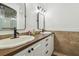 Bright bathroom features double sink vanity with stone countertop, stylish mirrors and modern fixtures at 1208 E Crenshaw St, Tampa, FL 33604