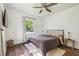 Bright bedroom featuring a ceiling fan, dark wood flooring, and natural light at 1208 E Crenshaw St, Tampa, FL 33604
