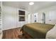 Well-lit bedroom with wood floors, fireplace, and access to laundry room and bath, offering convenience and style at 1208 E Crenshaw St, Tampa, FL 33604