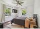 Cozy bedroom with a ceiling fan, two windows, and dark wood flooring at 1208 E Crenshaw St, Tampa, FL 33604