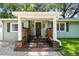 Inviting front porch with detailed wood railing leading to the main entrance at 1208 E Crenshaw St, Tampa, FL 33604