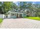 Charming single-story home showcasing manicured lawn and large brick paver driveway at 1208 E Crenshaw St, Tampa, FL 33604