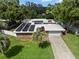 An aerial shot of a home with solar panels, a palm tree and a driveway leading to an attached garage at 1309 Eastfield Dr, Clearwater, FL 33764