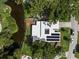 Aerial view of a modern home featuring solar panels, a manicured lawn, and waterfront access at 1309 Eastfield Dr, Clearwater, FL 33764