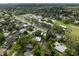 An aerial view featuring a modern home with water access nestled among lush trees in a charming neighborhood at 1309 Eastfield Dr, Clearwater, FL 33764