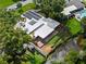 An aerial view of a home featuring a wooden deck, solar panels, and proximity to a tranquil body of water at 1309 Eastfield Dr, Clearwater, FL 33764