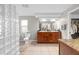 A large bathroom with dual vanities, a glass block shower and a separate tub at 1309 Eastfield Dr, Clearwater, FL 33764