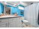 Bathroom featuring a blue wall, a mirror over the sink, and a white shower curtain at 1309 Eastfield Dr, Clearwater, FL 33764