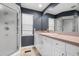 Bathroom featuring a gray wall, white cabinets, a large mirror, and stone floors at 1309 Eastfield Dr, Clearwater, FL 33764