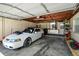 Garage featuring a white sports car, storage shelves, and a workbench at 1309 Eastfield Dr, Clearwater, FL 33764