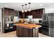 Modern kitchen with dark wood cabinetry, stainless steel appliances, and a wood topped island at 1309 Eastfield Dr, Clearwater, FL 33764