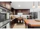 Kitchen with stainless steel appliances, wooden countertops and dark wood cabinetry with tile backsplash at 1309 Eastfield Dr, Clearwater, FL 33764