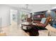 Stylish living room with a piano, exposed guitars, leather chairs, and exposed doors to the outdoor patio at 1309 Eastfield Dr, Clearwater, FL 33764