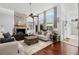 Bright living room with a stone fireplace, modern sofas, hardwood floors, and large windows at 1309 Eastfield Dr, Clearwater, FL 33764