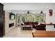 Spacious living room with a brick fireplace, a leather sofa and views of the well-manicured front yard at 1309 Eastfield Dr, Clearwater, FL 33764
