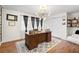 Home office features a large desk, dark accents, lots of shelving, and natural light at 1309 Eastfield Dr, Clearwater, FL 33764