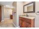 Bathroom featuring a wooden vanity with granite countertop, tile floors, and a framed mirror at 13167 Roseanna Dr, Spring Hill, FL 34609