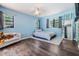 Stylish bedroom with wood floors, blue walls, and a comfortable bed with accent decor at 13167 Roseanna Dr, Spring Hill, FL 34609
