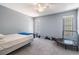 Serene bedroom with gray carpet, light blue walls, and plenty of natural light from large windows at 13167 Roseanna Dr, Spring Hill, FL 34609