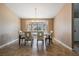 Cozy dining room featuring tile flooring, a chandelier, and a large bay window overlooking the front yard at 13167 Roseanna Dr, Spring Hill, FL 34609