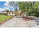 Home featuring a long driveway leading to a two-car garage and manicured landscaping at 13167 Roseanna Dr, Spring Hill, FL 34609