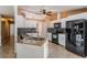 Kitchen featuring a granite island, white cabinets, tile backsplash, and modern stainless steel appliances at 13167 Roseanna Dr, Spring Hill, FL 34609