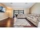 Spacious living room featuring hardwood floors, neutral walls, and a plush sectional sofa at 13167 Roseanna Dr, Spring Hill, FL 34609