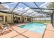 A screened-in pool with lounge chairs and an outdoor seating area offers a relaxing retreat at 13167 Roseanna Dr, Spring Hill, FL 34609