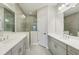 Modern bathroom with double vanity, large mirrors, tiled floors, and walk-in shower at 13524 Circa Crossing Dr, Lithia, FL 33547
