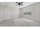Spacious carpeted bedroom with a ceiling fan and natural light from a large window at 13524 Circa Crossing Dr, Lithia, FL 33547