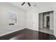 Cozy bedroom features dark hardwood floors, natural light from the window, and an attached bathroom at 13524 Circa Crossing Dr, Lithia, FL 33547