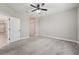 Bedroom features neutral walls, gray carpet, ceiling fan and a doorway leading to a hallway at 13524 Circa Crossing Dr, Lithia, FL 33547