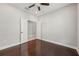 Bedroom features hardwood floors, neutral walls, ceiling fan, and doorway with neutral paint and white trim at 13524 Circa Crossing Dr, Lithia, FL 33547