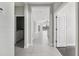 Bright hallway features white tile flooring, leading to the laundry room and an open-concept living area at 13524 Circa Crossing Dr, Lithia, FL 33547