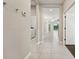 Bright hallway featuring neutral paint, tiled floors, laundry, and access to various rooms at 13524 Circa Crossing Dr, Lithia, FL 33547