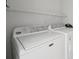 Functional laundry room featuring white Maytag appliances and wire shelving for organized storage at 13524 Circa Crossing Dr, Lithia, FL 33547