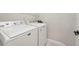 Laundry room has a white Maytag washer and dryer with white walls, and a wire rack at 13524 Circa Crossing Dr, Lithia, FL 33547