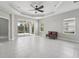 Spacious living room features a tray ceiling, ceiling fan, neutral finishes, and sliding glass doors to the outdoors at 13524 Circa Crossing Dr, Lithia, FL 33547